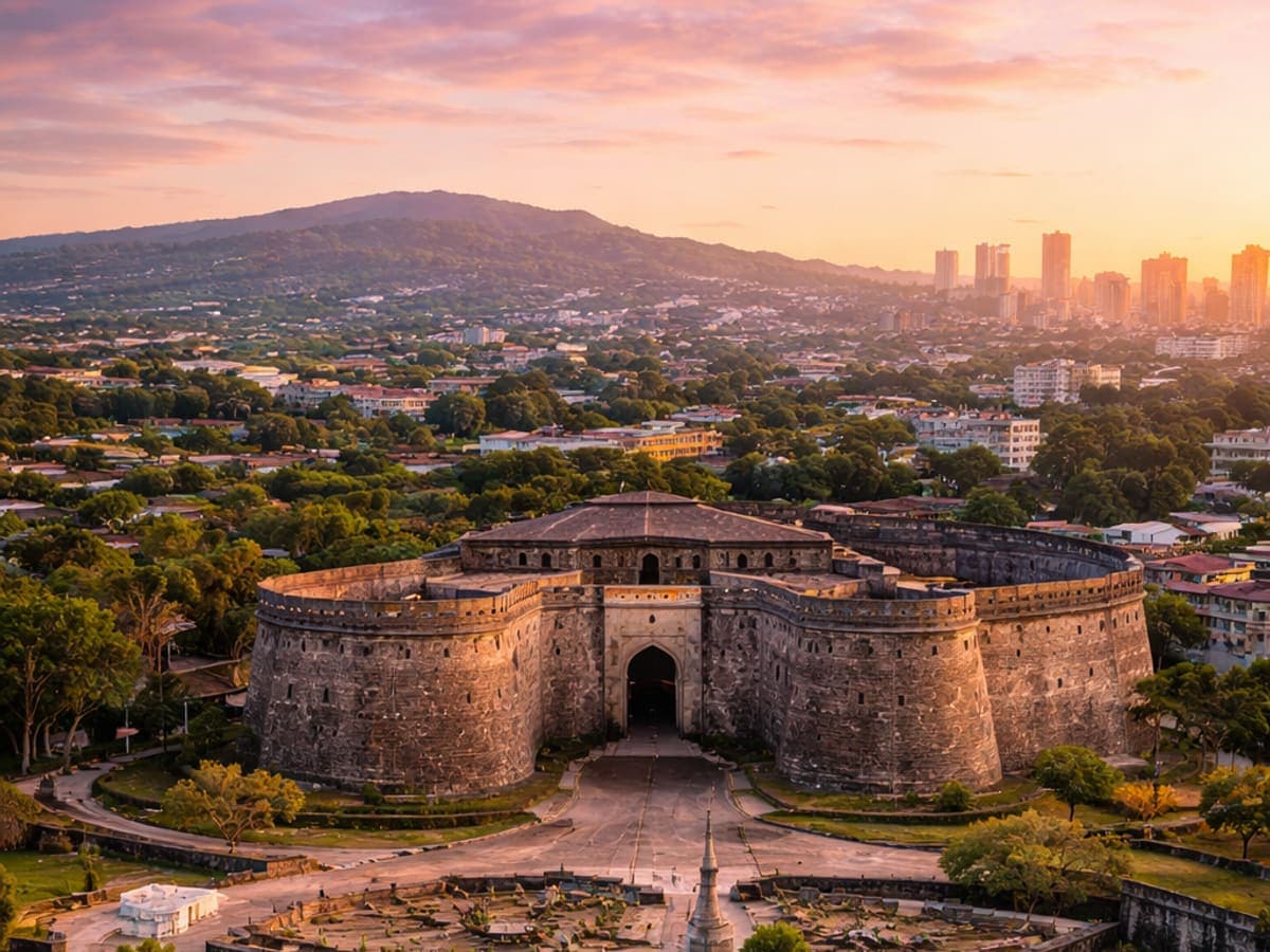 Aerial view of Shaniwar Wada fort in Pune at sunset, with the city skyline behind
